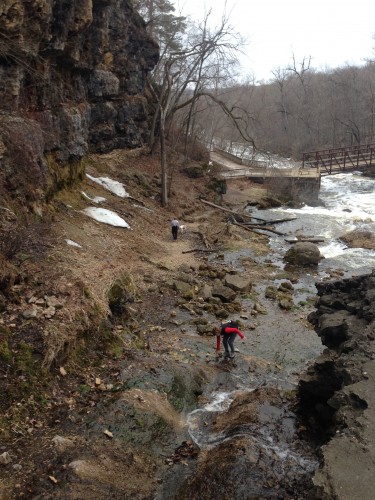 My family climbing around the side of the falls at Willow River State Park