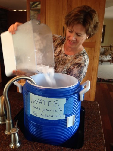 Mom filling up the water jug she puts out for thirsty runners/bikers/roller skiers at the bottom of the driveway. 